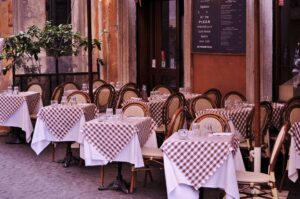 Italienisches Restaurant mit gedeckten Tischen am Straßenrand